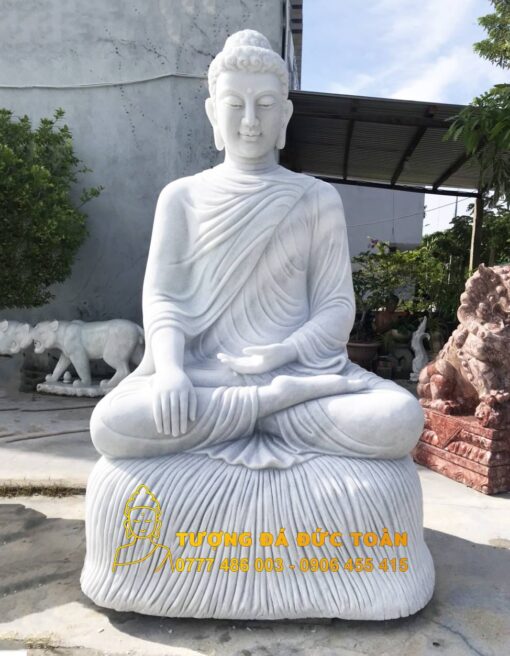 A Bán Tượng Phật Thích Ca Mâu Ni đá thạch thạch ngồi trong vườn.