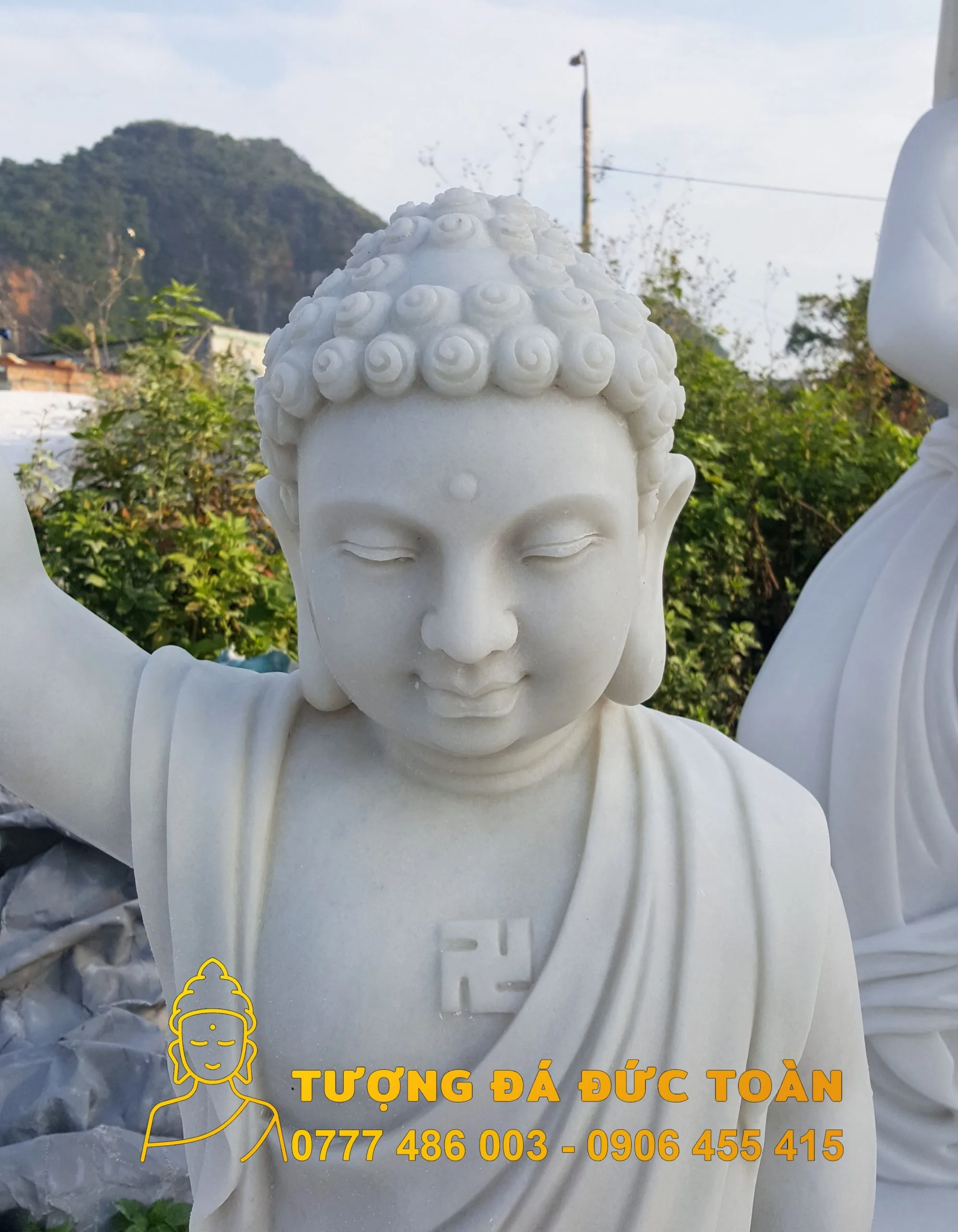 Tượng Phật Đản Sanh đá cẩm thạch trắng tự nhiên trước núi.