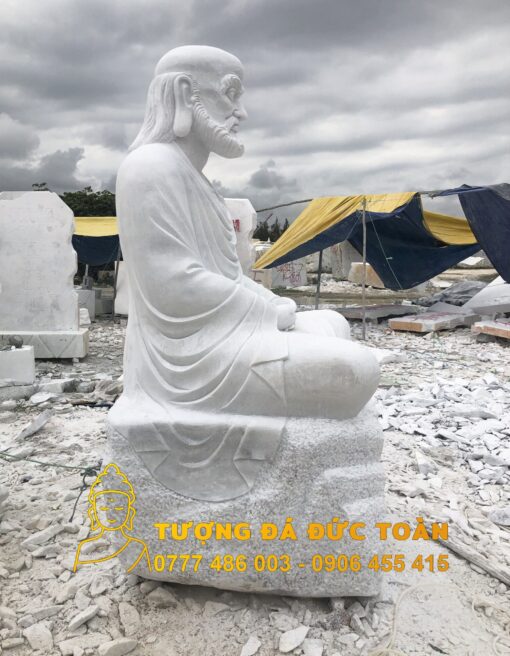 Tượng Đức Đạt Ma Tổ Sư đá đẹp hàng đầu Đà Nẵng màu trắng ngồi trên đống đá đẹp ở Đà Nẵng.