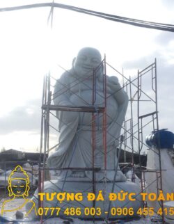 Tượng Bán tượng Phật Di Lặc đứng đá tự nhiên ngồi trên giàn giáo.