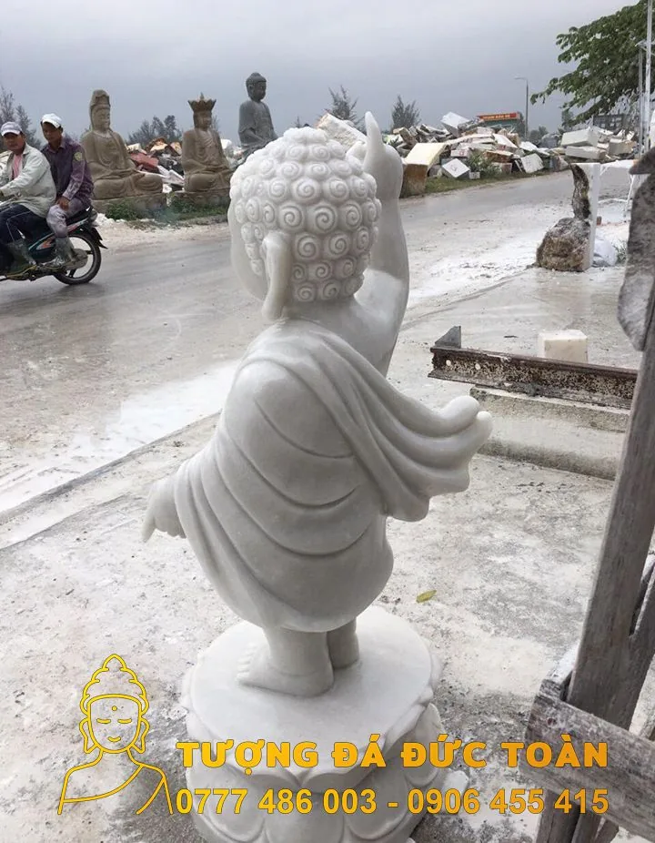 Tượng Phật Đản Sanh đá đẹp tự nhiên màu trắng trên đường phố.