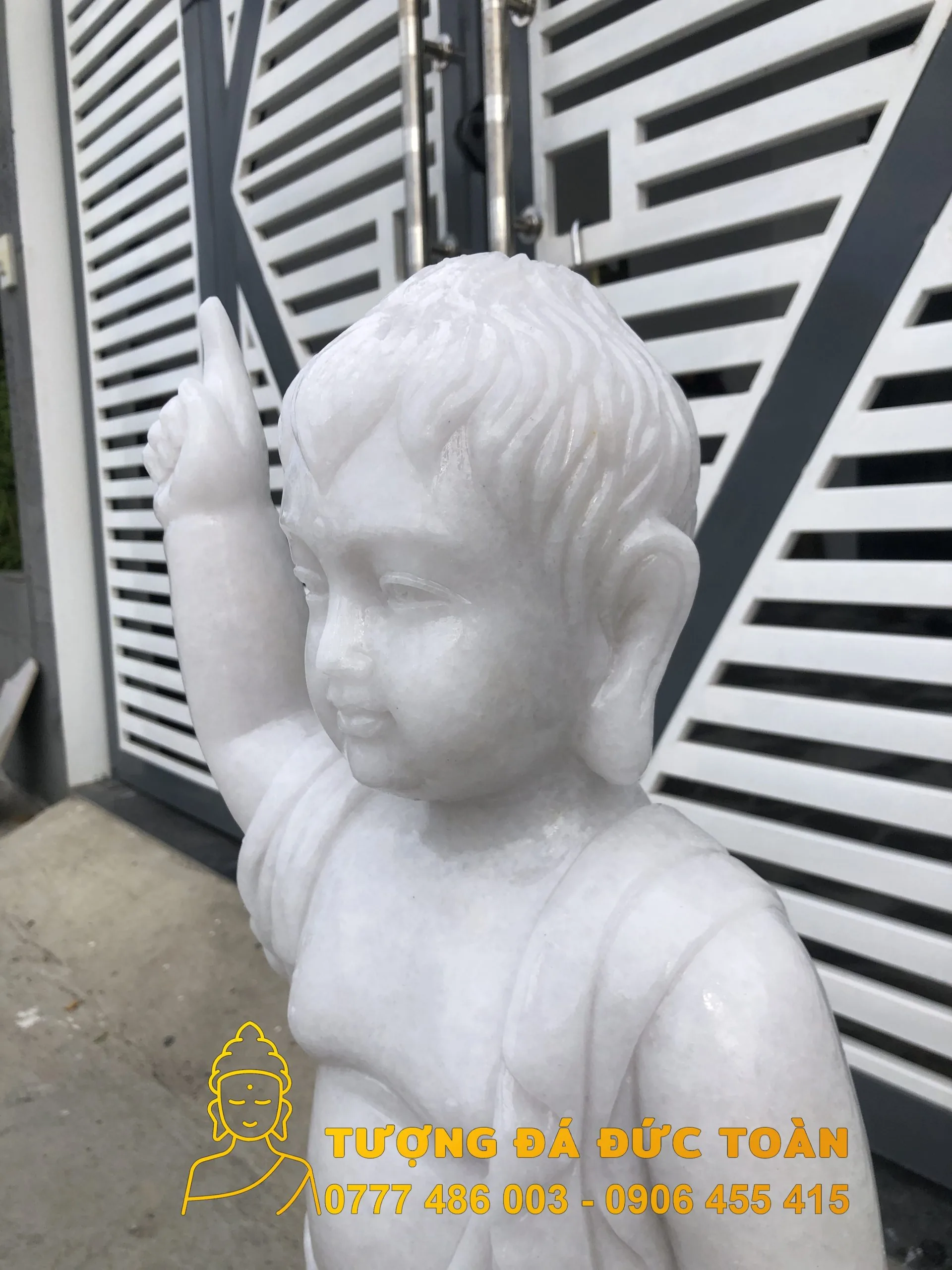 Tượng một cậu bé màu trắng giơ tay lên giống như Tượng Phật Đản Sanh đá nguyên khối cầu Đường.