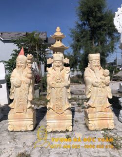 Bốn tượng tượng Phước Lộc Thọ đá cẩm thạch vàng giá rẻ trước một khu vườn.