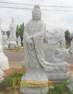 Tượng Phật Quan Âm dựng dài bằng đá trắng trên đường phố.