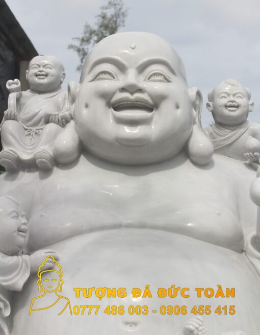 Tượng Phật Di Lặc màu trắng ngồi cầm viết như ý của Phật đang mỉm cười.