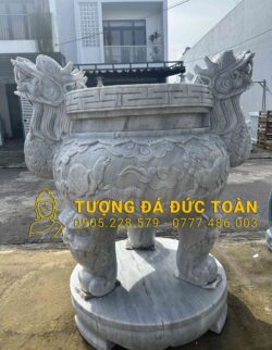 A TƯỢNG KỲ LÂN ĐẾ CHẠM TỨ LINH ĐÁ CẨM THẠCH XÁM có hình rồng trên đó.