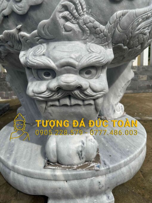 A TƯỢNG KỲ LÂN ĐẾ CHẠM TỨ LINH ĐÁ CẨM THẠCH XÁM có đầu rồng trên đó.