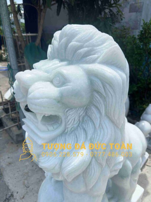 Một bức tượng sư tử trắng được trưng bày trước một tòa nhà.