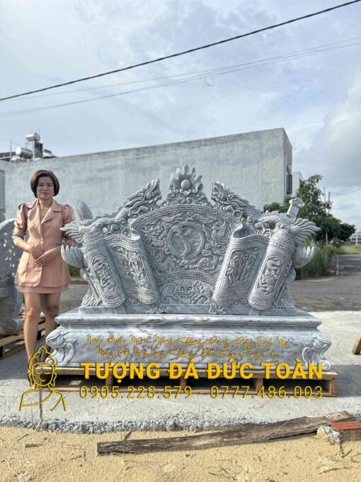 Một người phụ nữ đang đứng cạnh một bức tượng lớn.