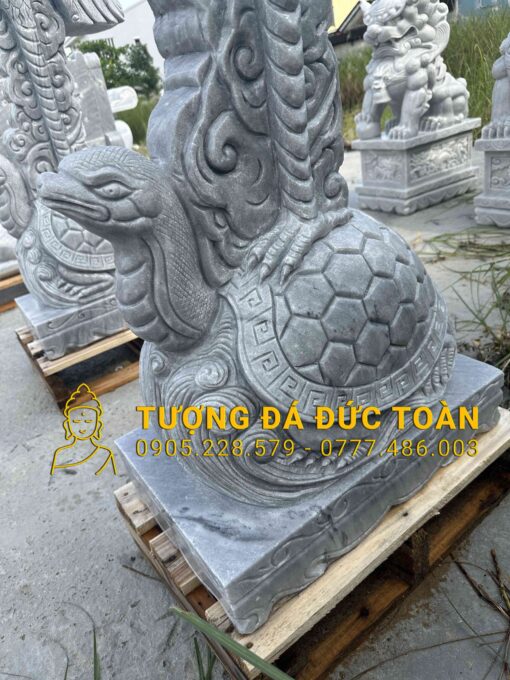 Một nhóm tượng đá có hình một con rùa trên đó.