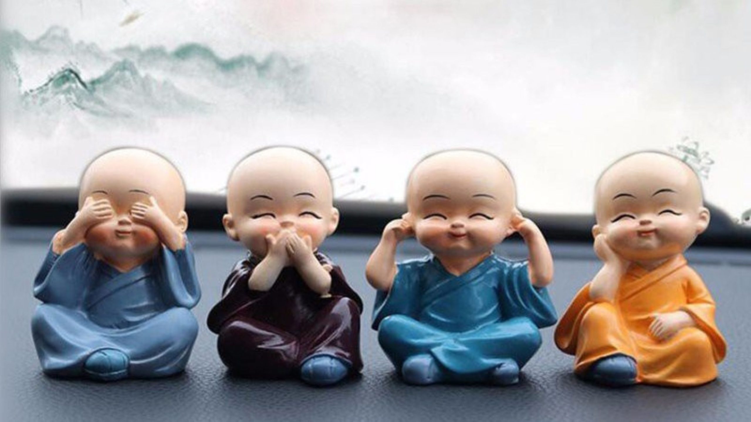 Bốn tượng chú tiểu ngồi trên bảng điều khiển ô tô.