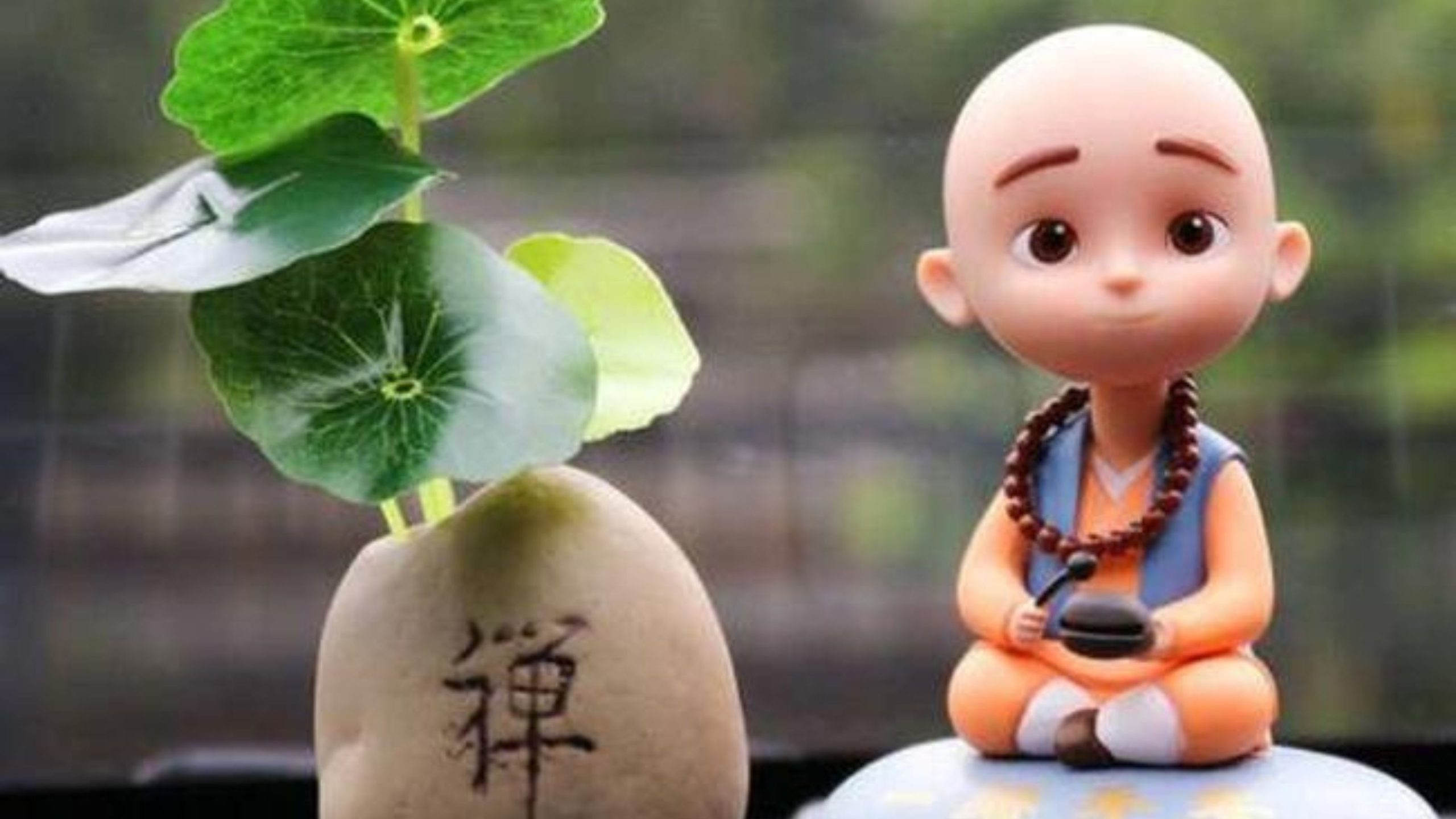 Một bức tượng chú tiểu ngồi cạnh một cái cây.