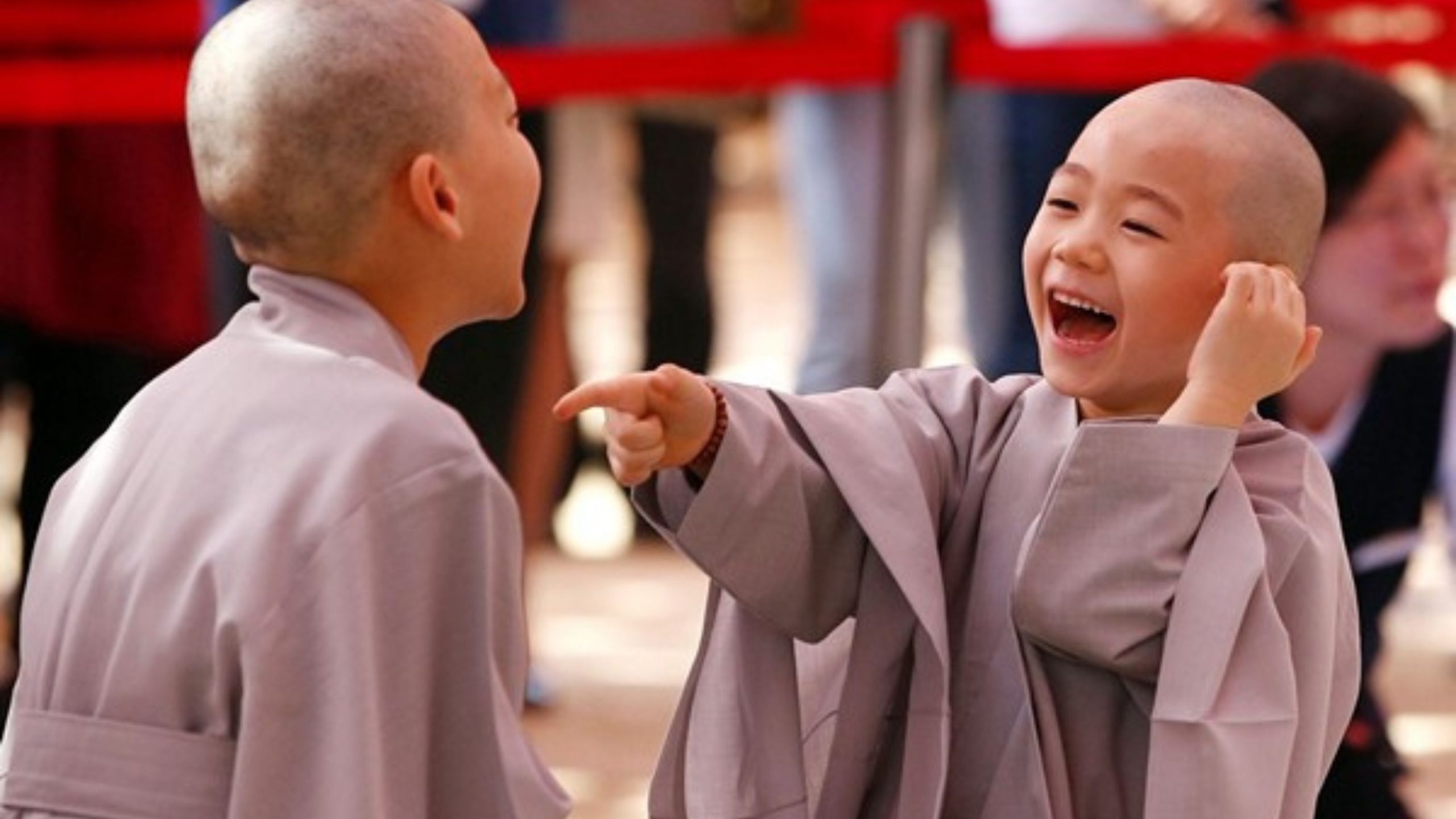 Hai nhà sư chú tiểu cười tươi trước đám đông.