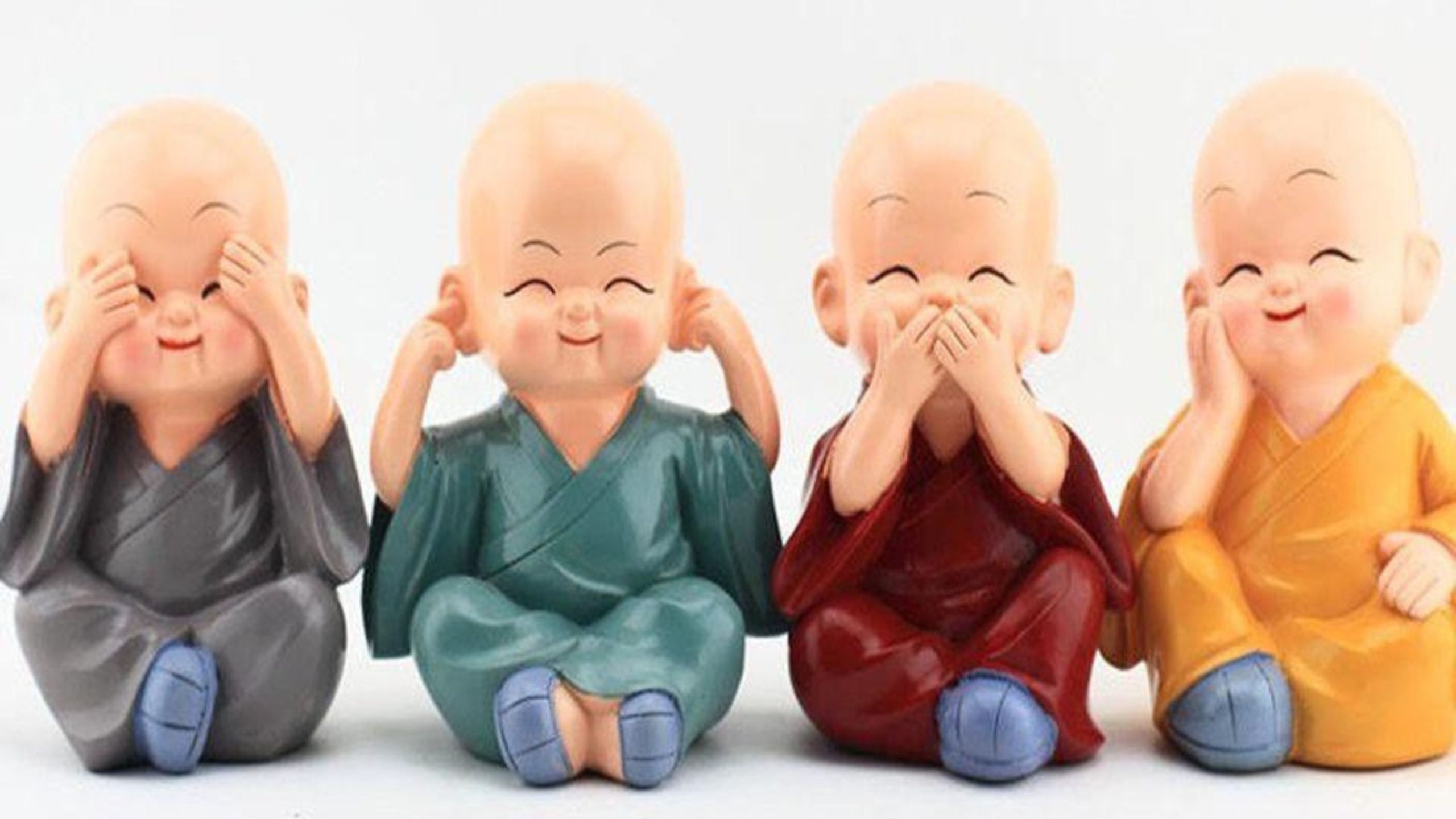 Bốn bức tượng nhỏ chú thích ngồi trên nền trắng.